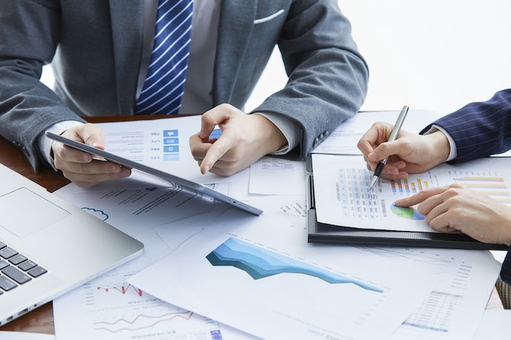 Business team analyzing graphs and data on tablet for Vietnam market expansion.